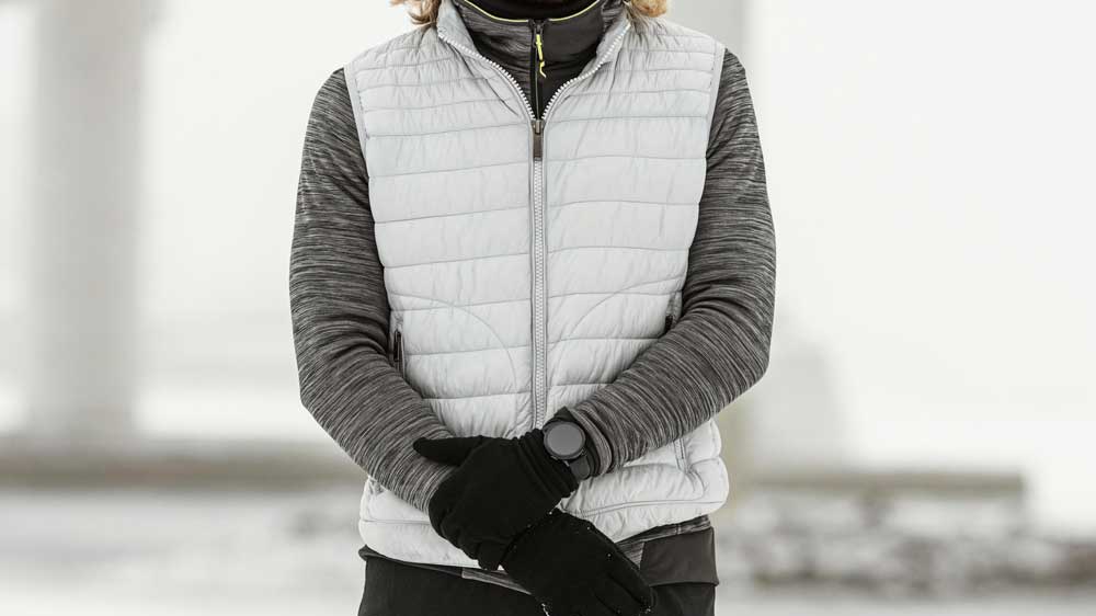 Un homme qui porte un bodywarmer dans un paysage d’hiver lors de ses activités sportives.